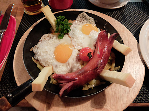 “巨大なソーセージと目玉焼きがのったポテト料理@Barry’s”